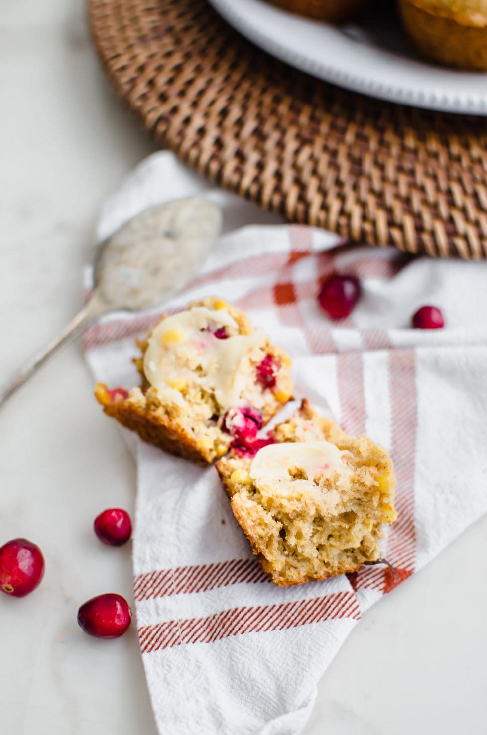 A close up shot of a muffin split in half and spread with honey butter. 