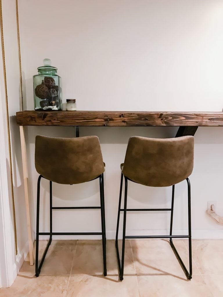 A photo of two leather chairs in front of a rustic wood counter top.