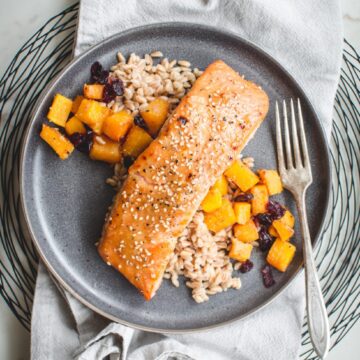 An overhead shot of a gray plate with miso maple roasted salmon, farro, and butternut squash on top.