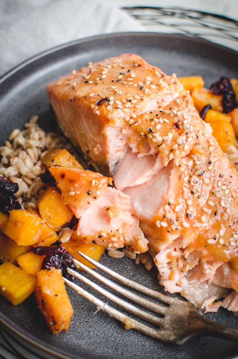 An overhead shot of a piece of roasted salmon being flaked with a fork.