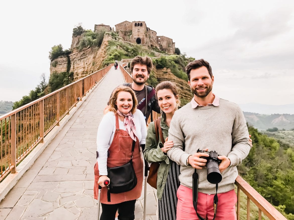 Two couples on the bridge in front of the Civita di Bagnoregio in Italy.