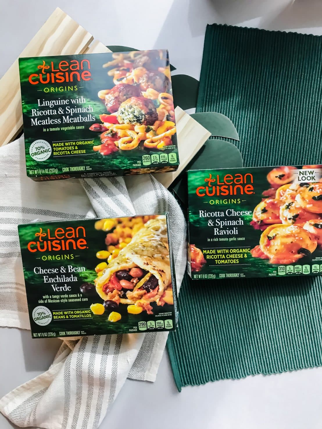 An overhead shot of three boxes of Lean Cuisine sitting on a green place mat. 