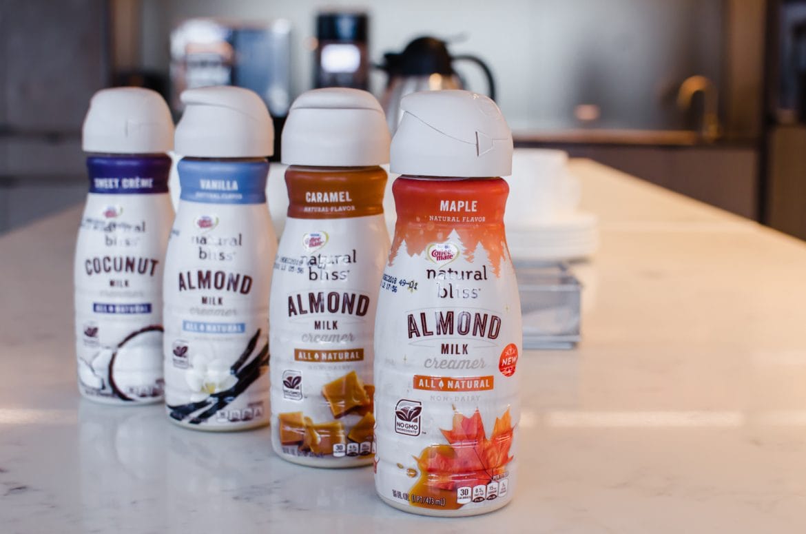 A line of Coffee Mate natural bliss creamers on a white counter top.