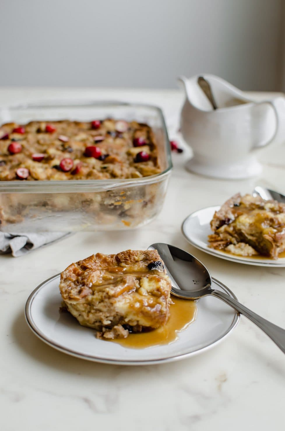 A plate of bread pudding with vanilla butter sauce spooned over the top.