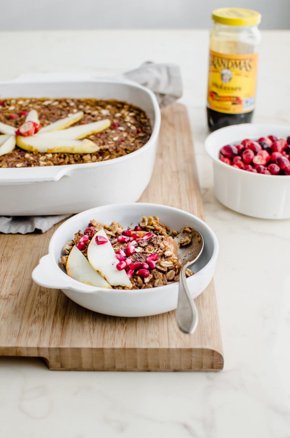 A white dish of gingerbread baked oatmeal on a current board. 