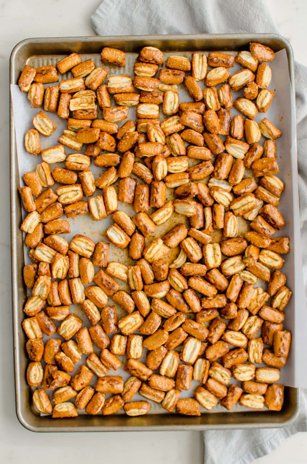 A baking sheet filled with Ranch pretzels that are about to be baked. 