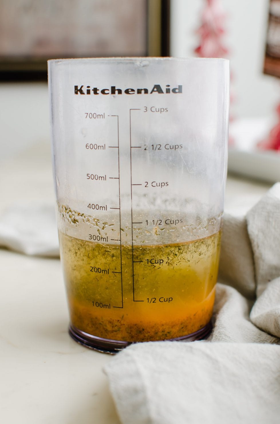 A liquid measuring cup with oil and ranch mix inside. 