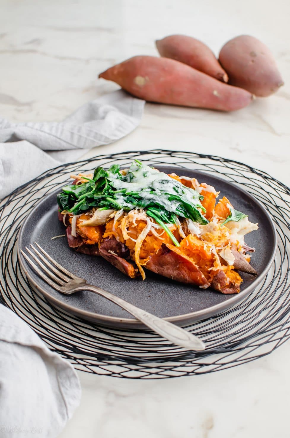 A grey plate with a Buffalo Chicken Stuffed Sweet Potato on top.