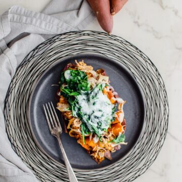 A grey plate with a Buffalo Chicken Stuffed Sweet Potato on top.