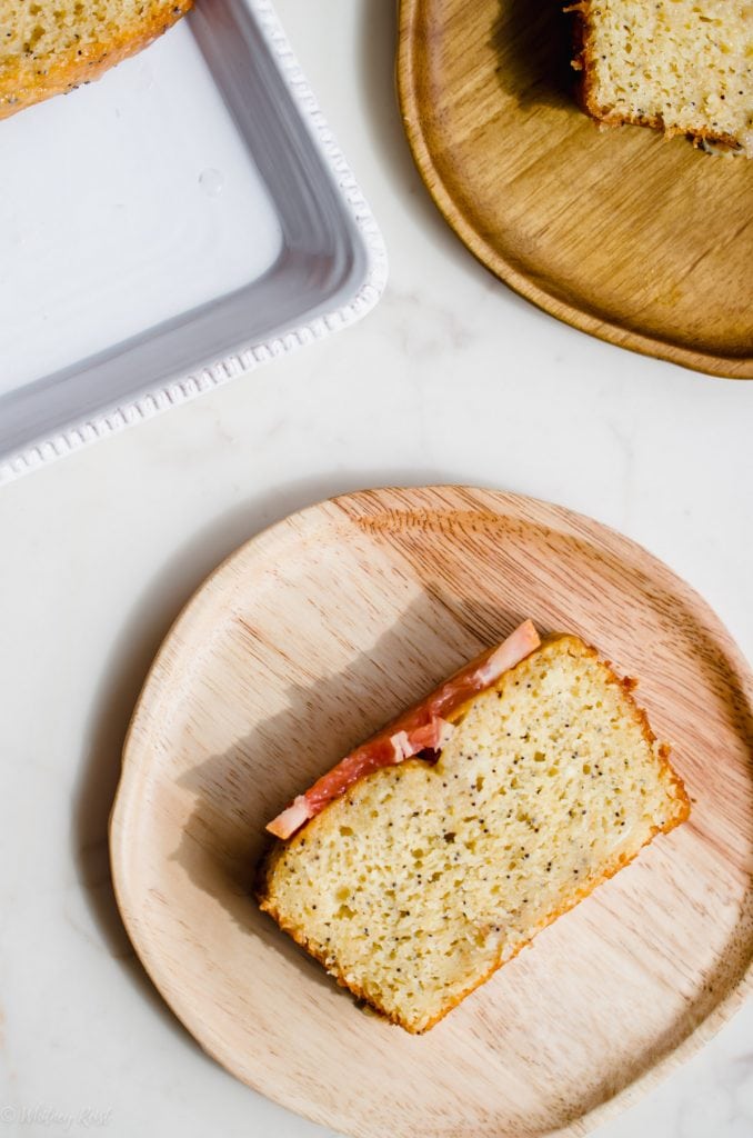 A wooden plate with a sliced of grapefruit bread on it. 