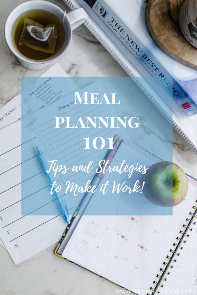 Menu planning sheets with a planner and apple on a white marble counter.