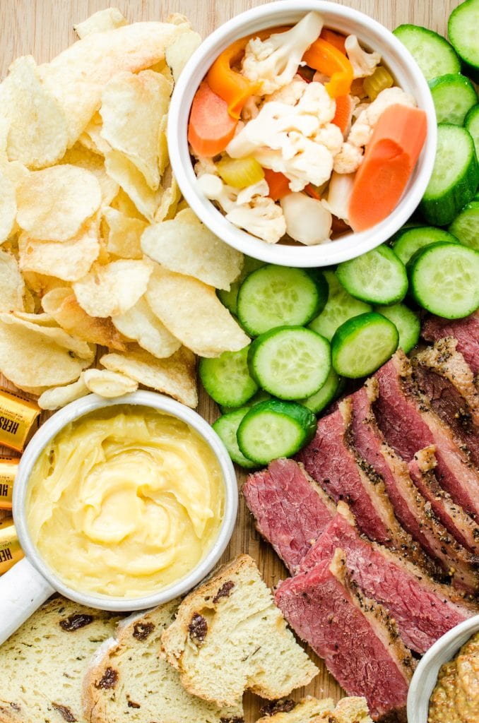 A wooden board filled with grazing platter foods for St. Patrick's Day.