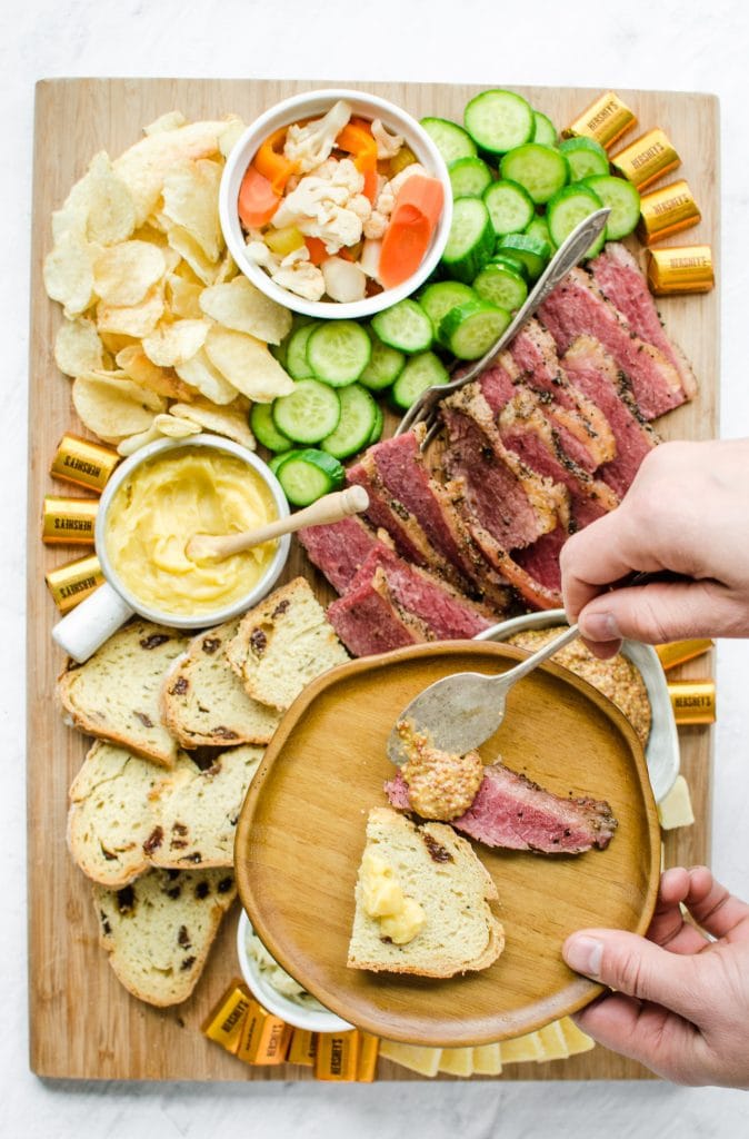 A wooden board filled with grazing platter foods for St. Patrick's Day.