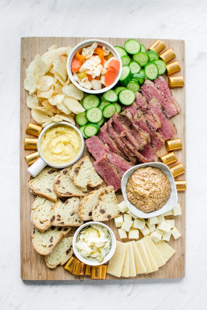 A wooden board filled with grazing platter foods for St. Patrick's Day.