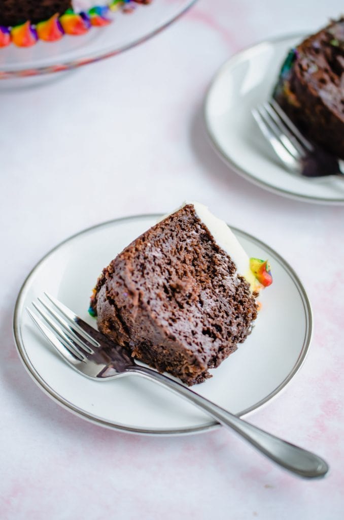 A white china plate with a piece of chocolate stout cake and a fork. 