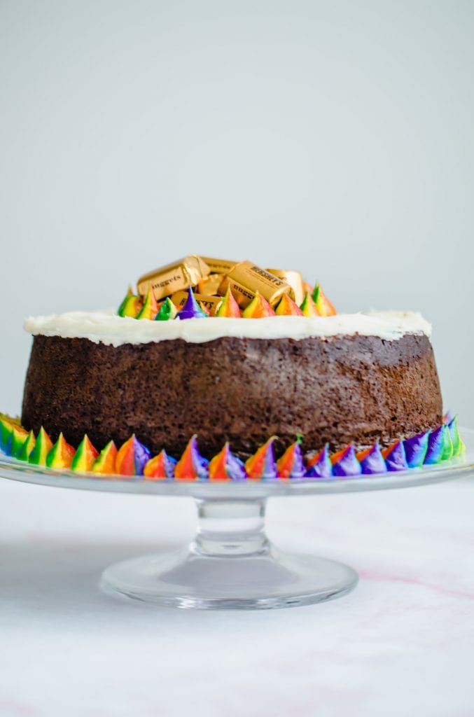 A shot of a Pot O' Gold Chocolate Stout Cake on a glass cake stand.