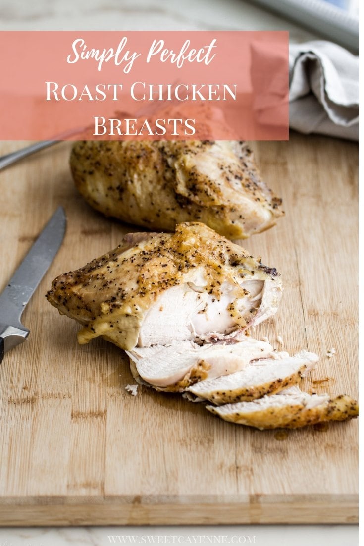 A roasted chicken breast being sliced on a cutting board on a white marble counter top.