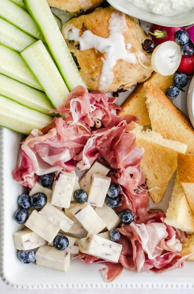 A close up shot of prosciutto and blueberry cheddar on an Easter brunch grazing board.