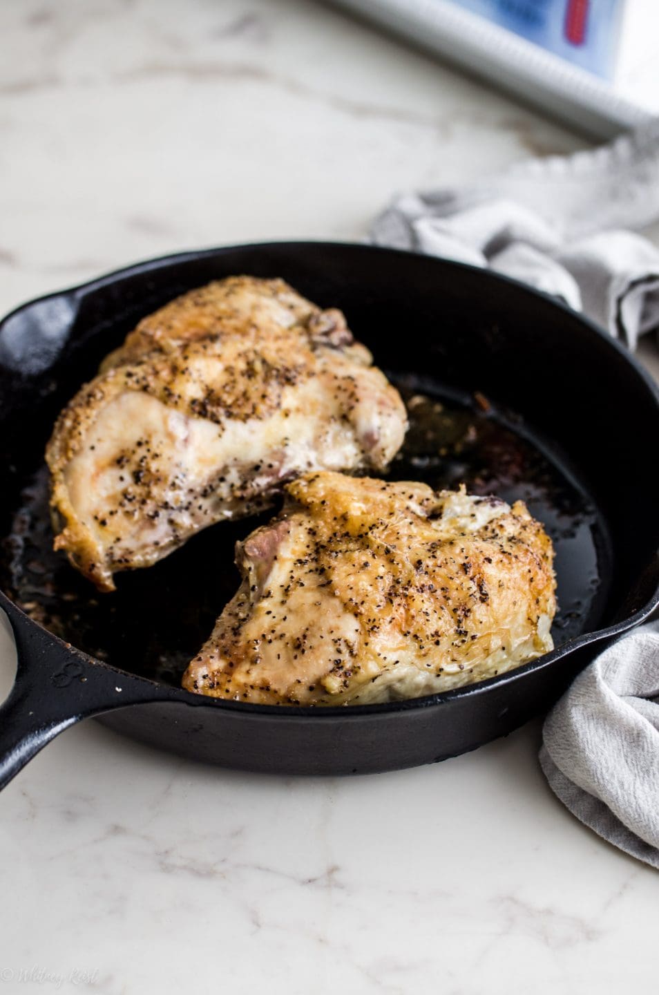 Cooked roast chicken breasts in a cast iron skillet. 