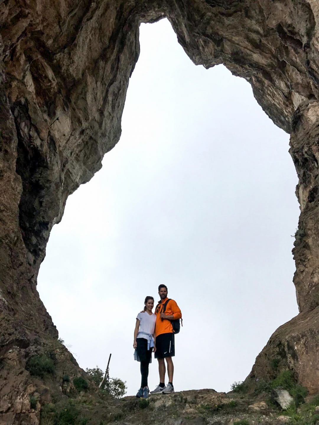 A couple standing in a rock formation. 