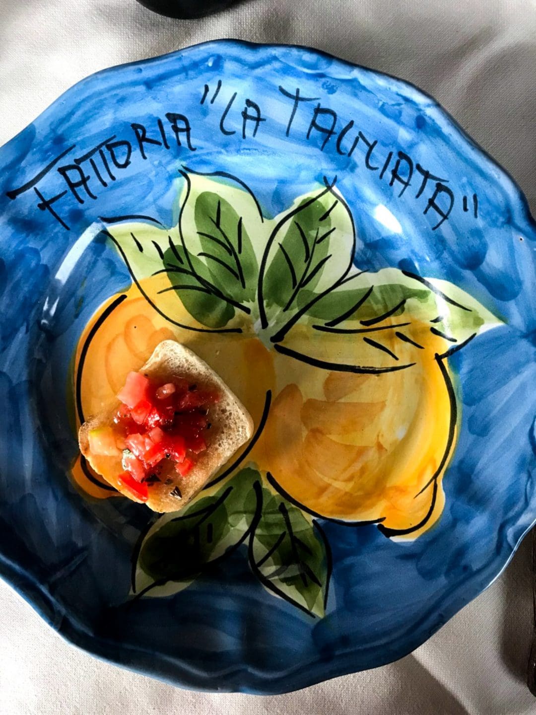 A painted plate sohowcasing lemons. 