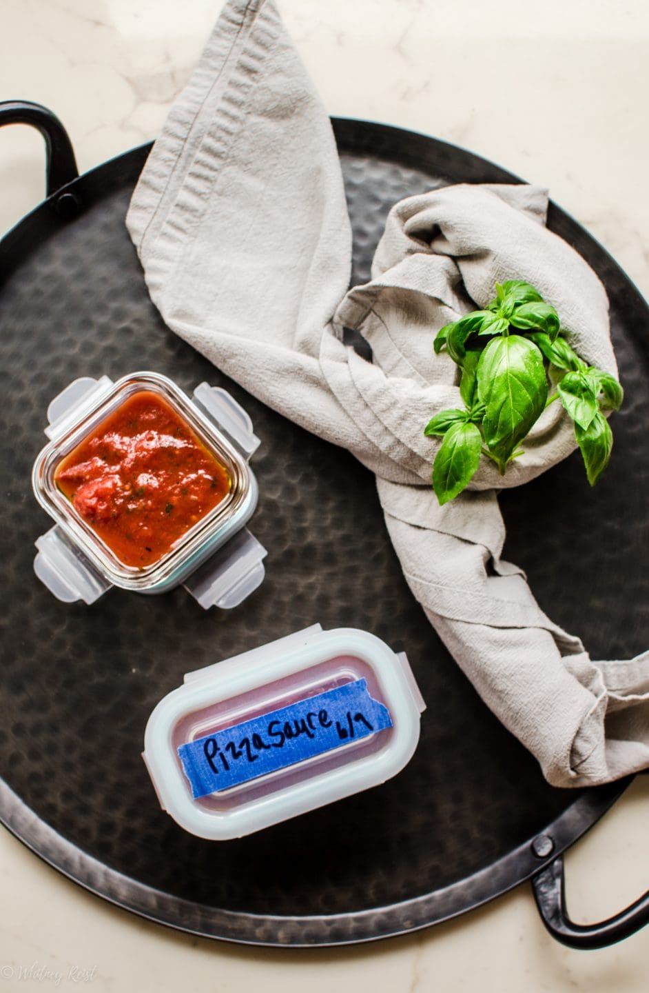 Small containers filled with pizza sauce ready to freeze for later. 