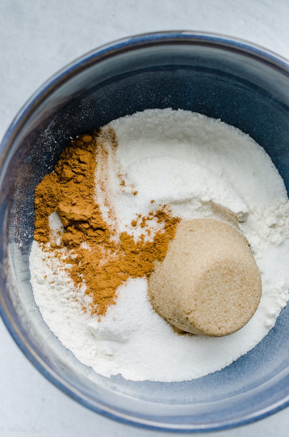 A mixing bowl filled with flour, sugar, and cinnamon.