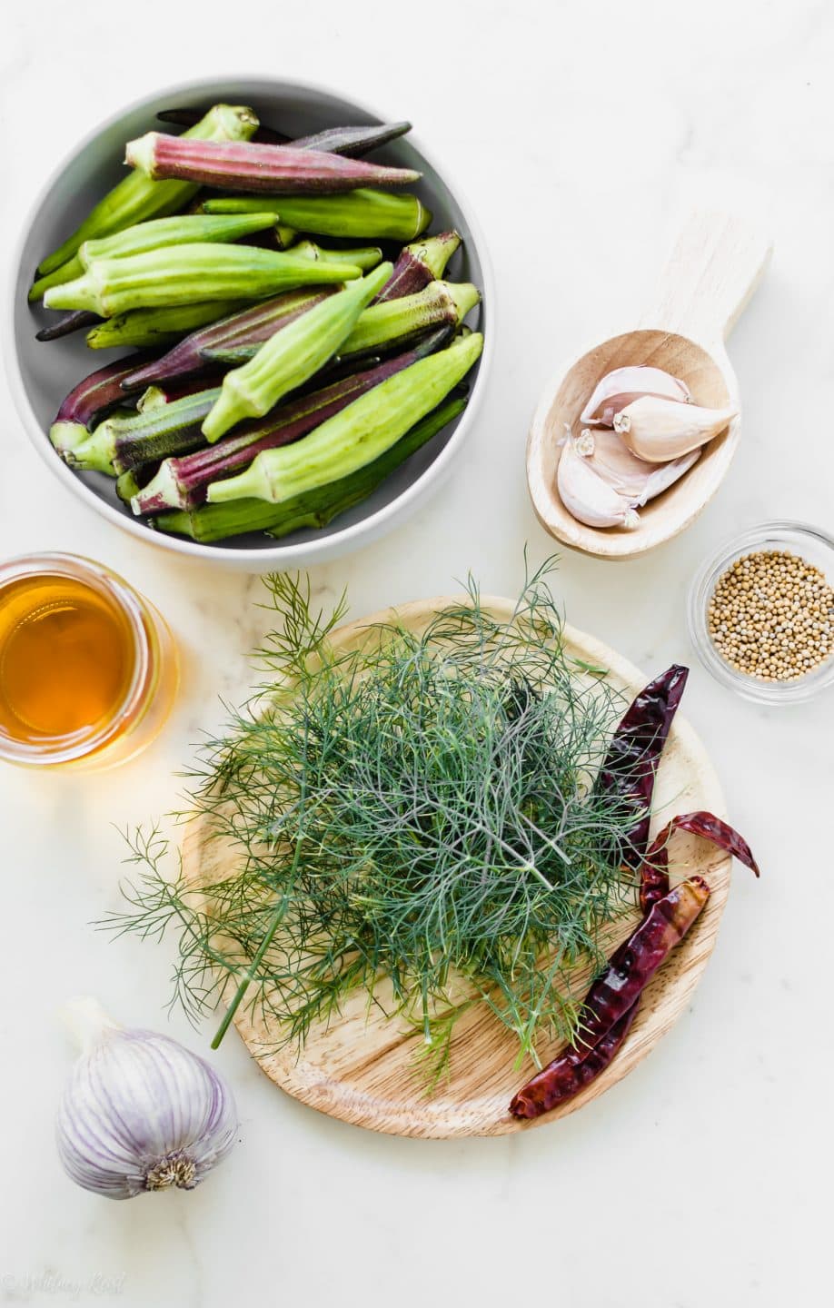 An overhead shot of prep bowls filled with ingredients for refrigerator spicy pickled okra.