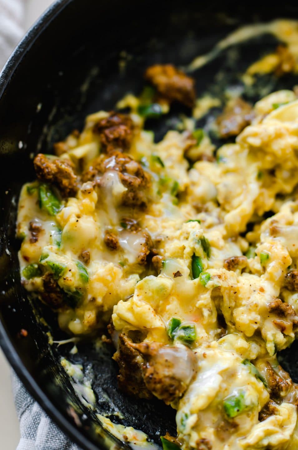 Eggs scrambled with chorizo and cheese in a cast iron skillet. 