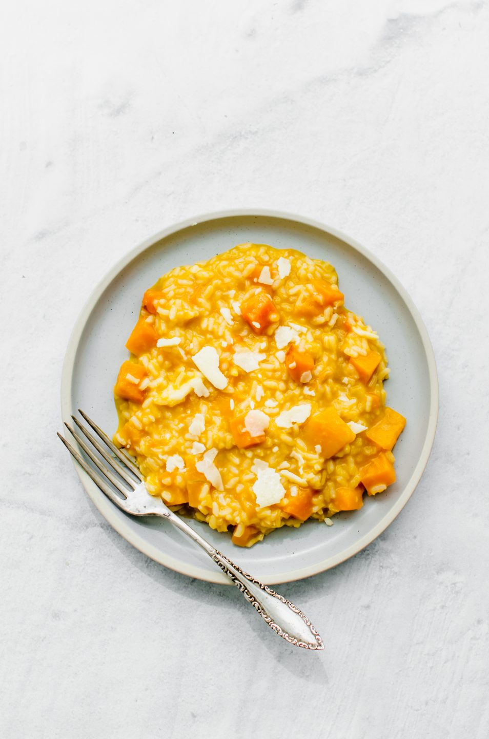 An overhead shot of a blue ceramic plate with butternut squash risotto.