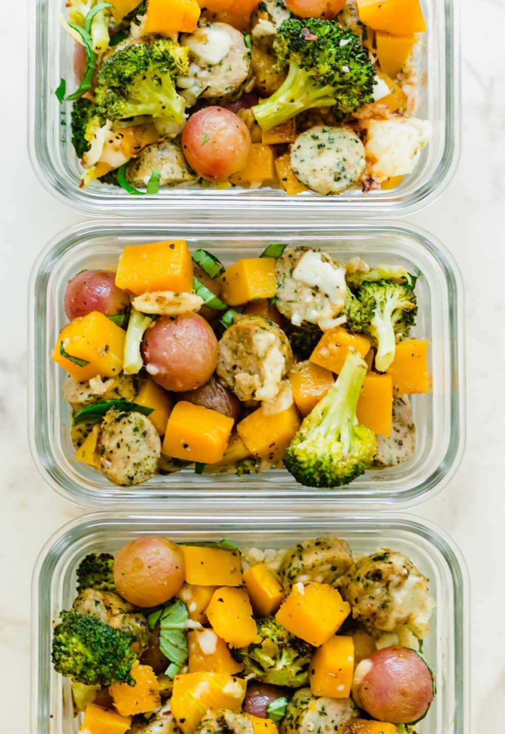 An overhead shot of glass meal prep containers filled with roasted veggies.