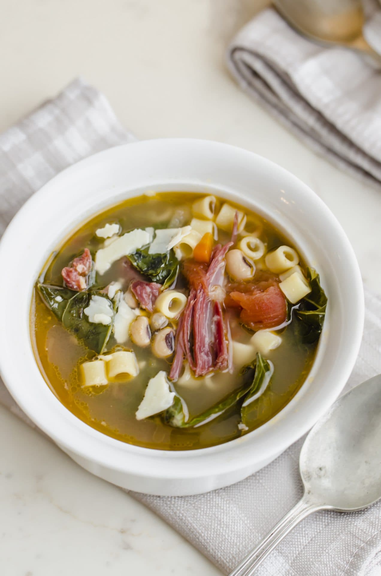 An up-close shot of a white bowl of Southern-style pasta e Fagioli.