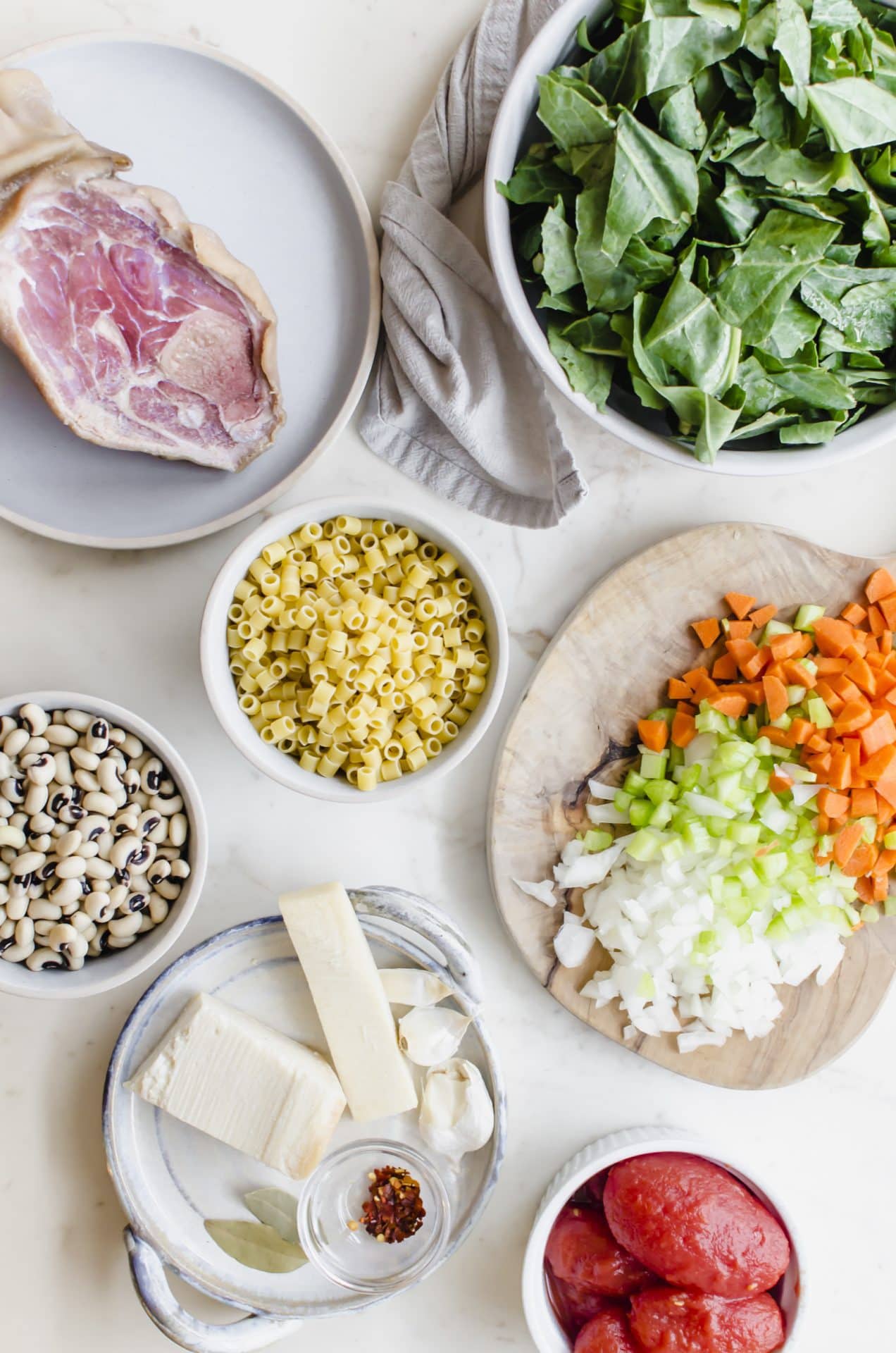 An overhead shot of prep bowls and boards with all the ingredients for Southern-style pasta e Fagioli.