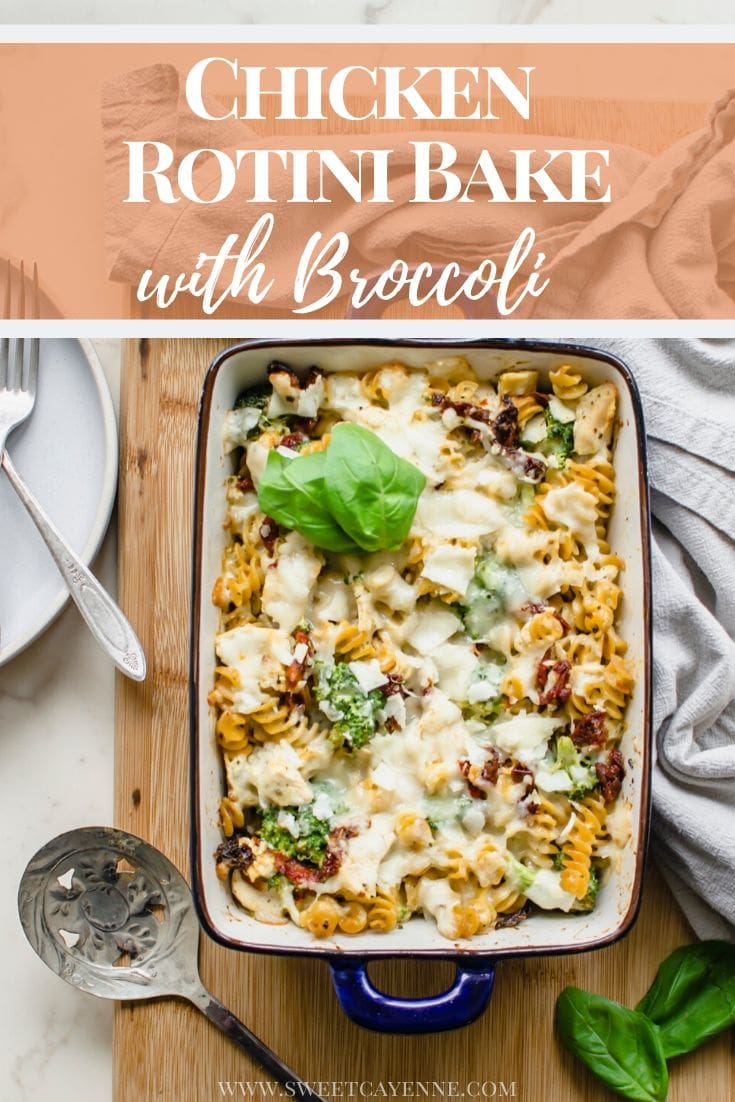 A blue casserole dish with Chicken Rotini Bake on a cutting board with a dish towel and serving spoon on the side.