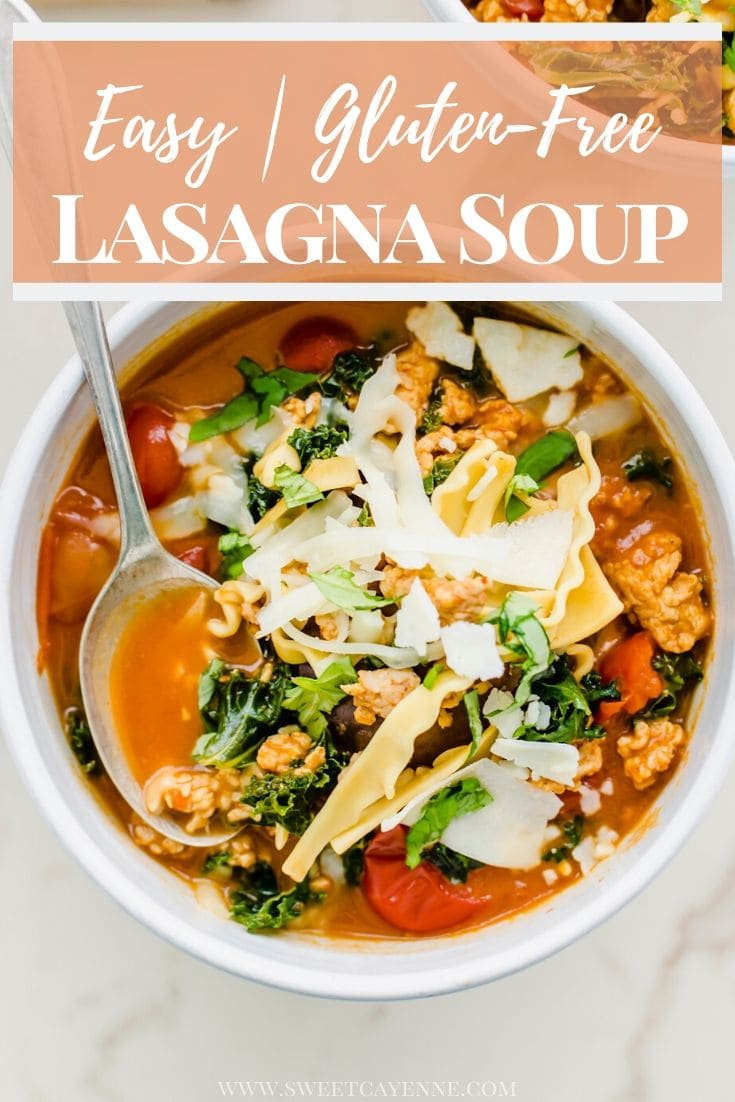 A white bowl filled with lasagna soup and topped with cheese and a spoon in the bowl.