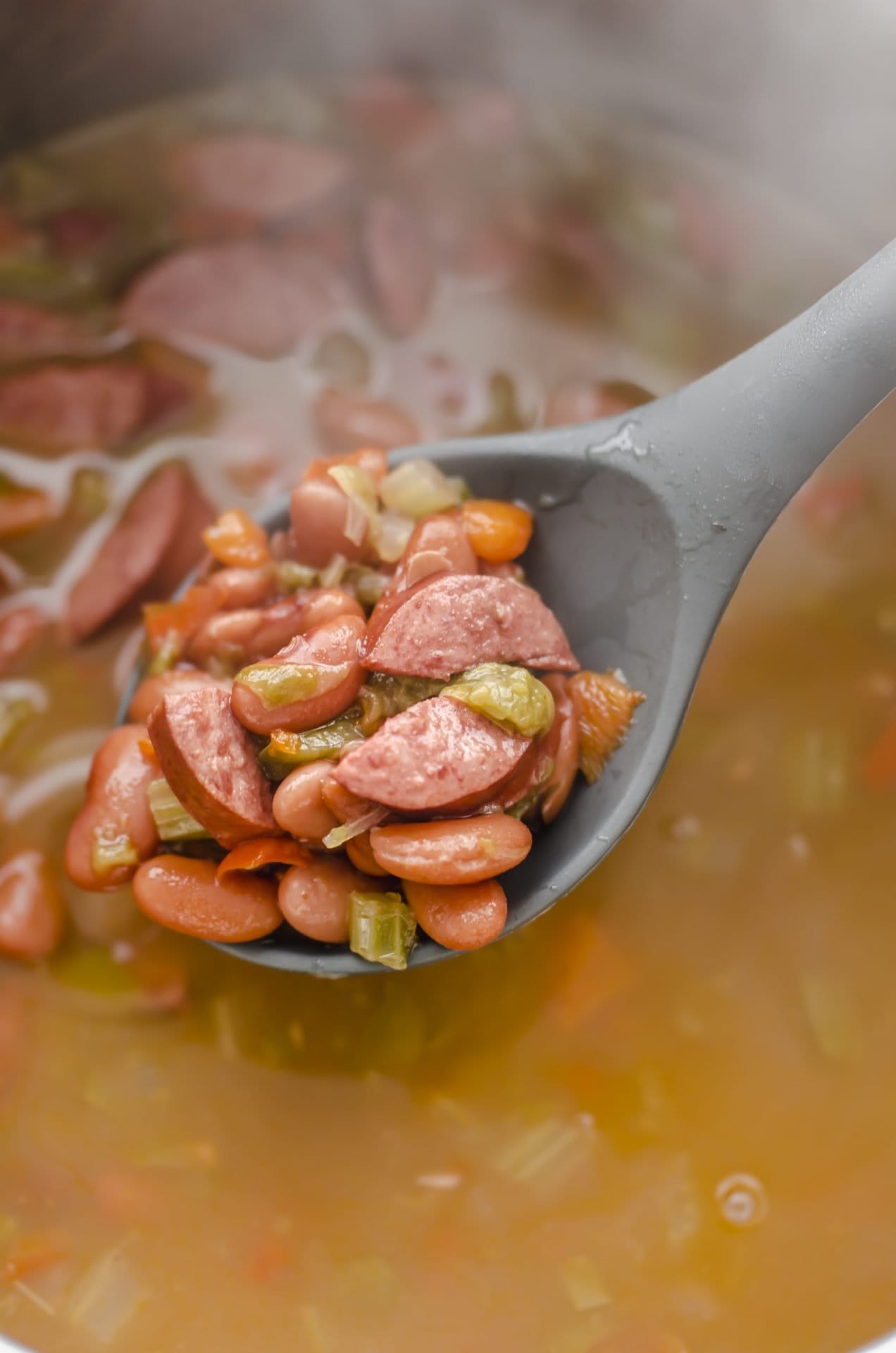 A spoon scooping out red beans and rice from the inside of an Instant Pot.