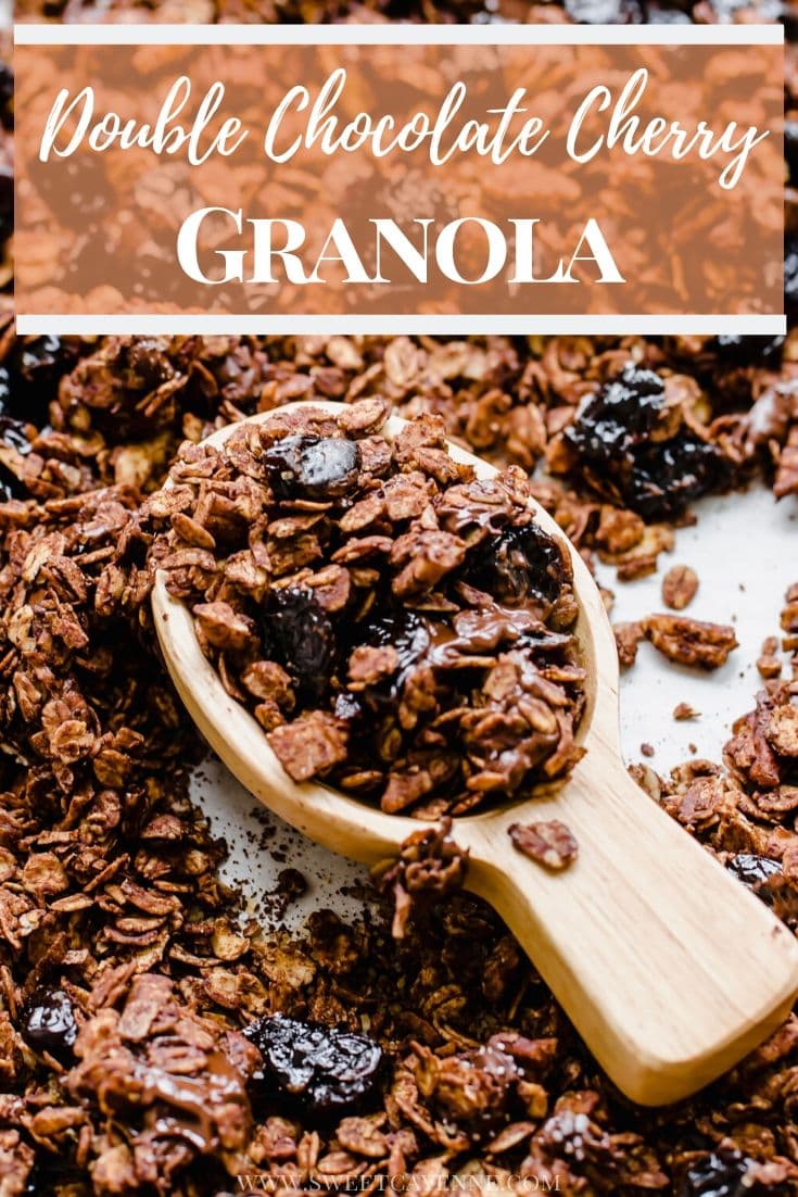 A wooden scoop filled with chocolate granola on a pan of granola.