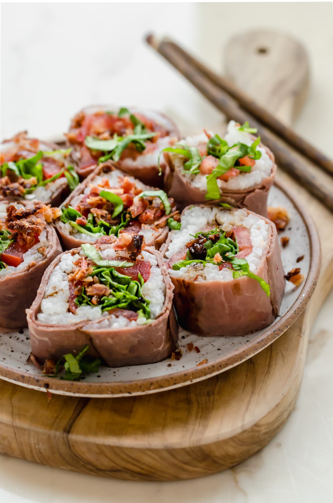 Close-up shot of a plate of beefshi BLT roll slices. 