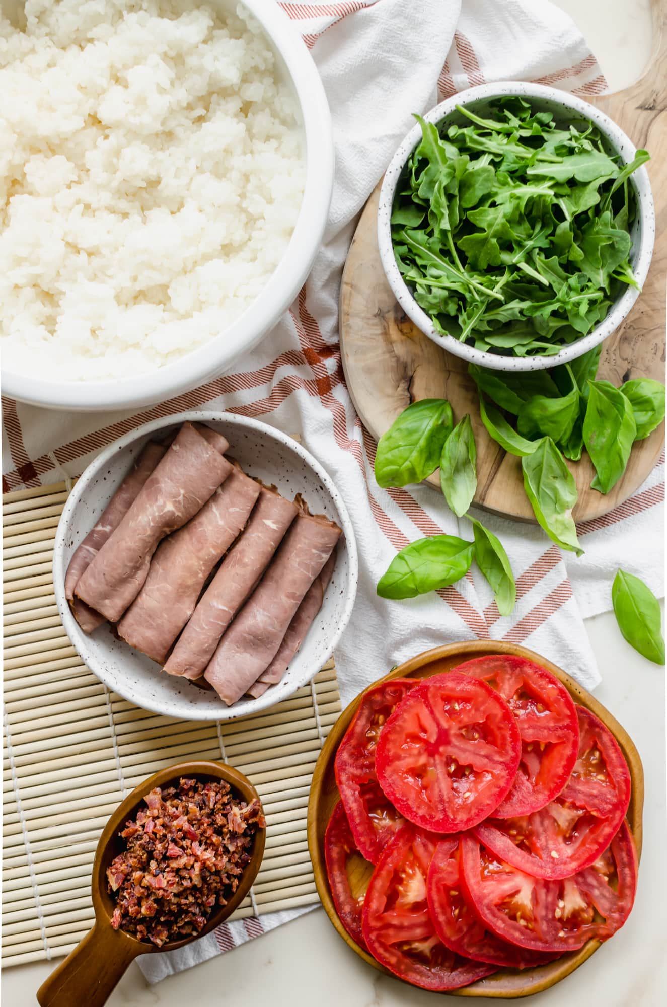 Bowls of prepared ingredients styled for making a beefshi roll. 