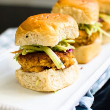 Two buffalo salmon sliders on a white ceramic serving tray.