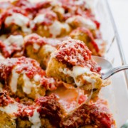Glass cooking dish with roasted cauliflower topped with tomato sauce and melted mozzarella cheese.