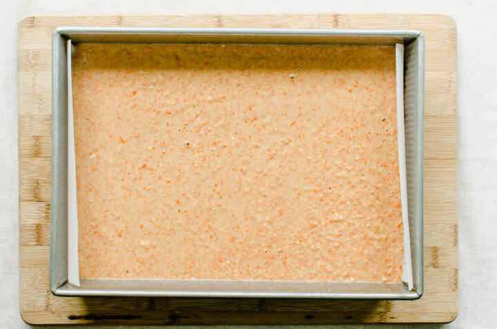 Carrot cake batter in a parchment lined baking pan.