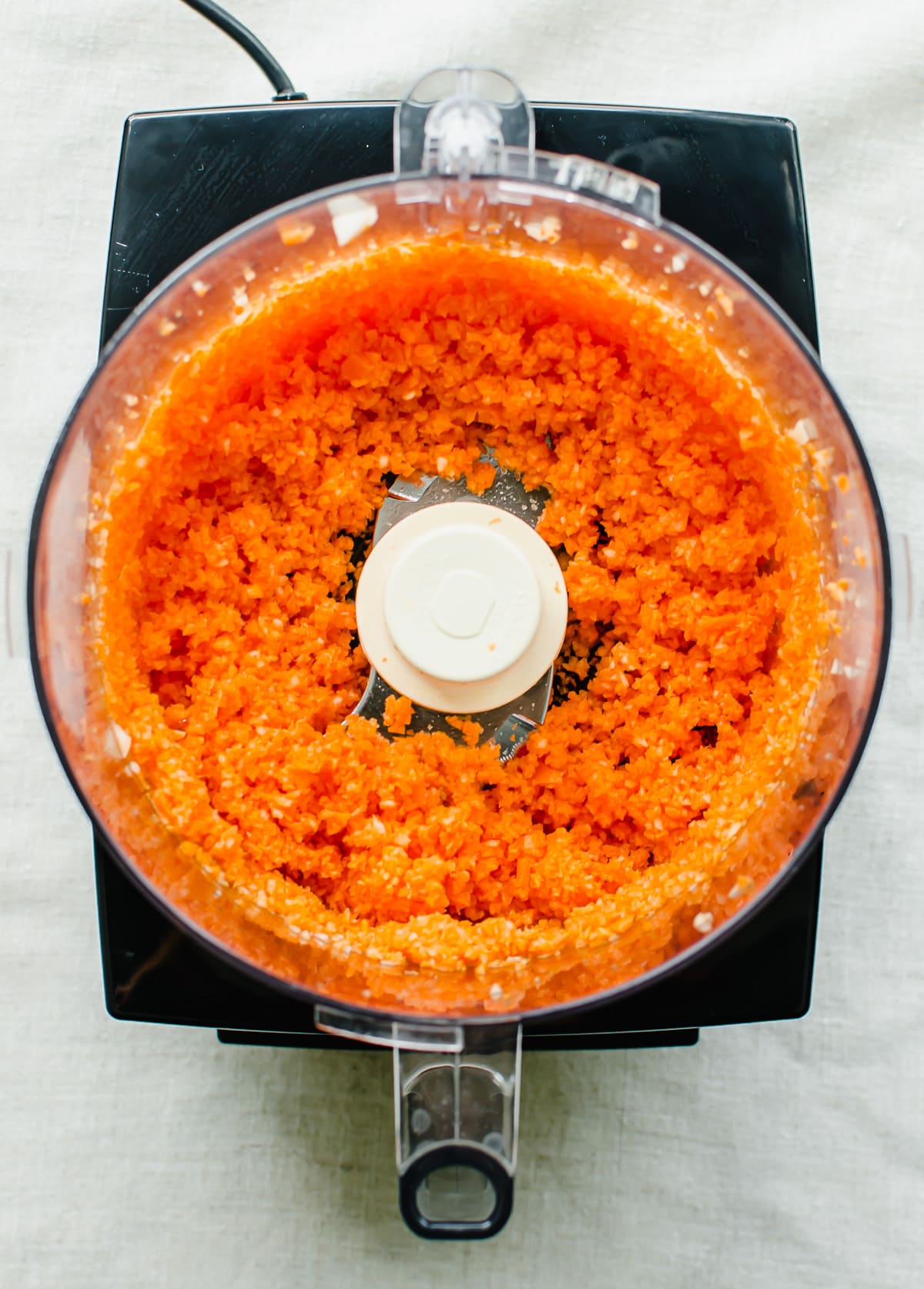 Grated carrots in the bowl of a food processor.