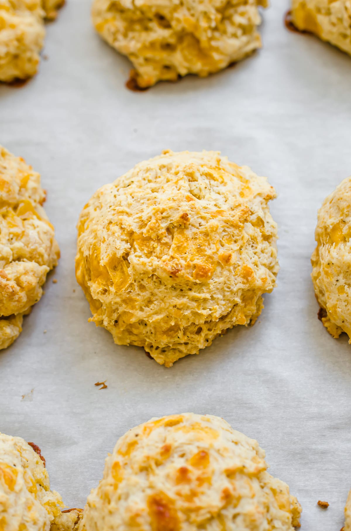 Cheddar bay biscuits on parchment paper.