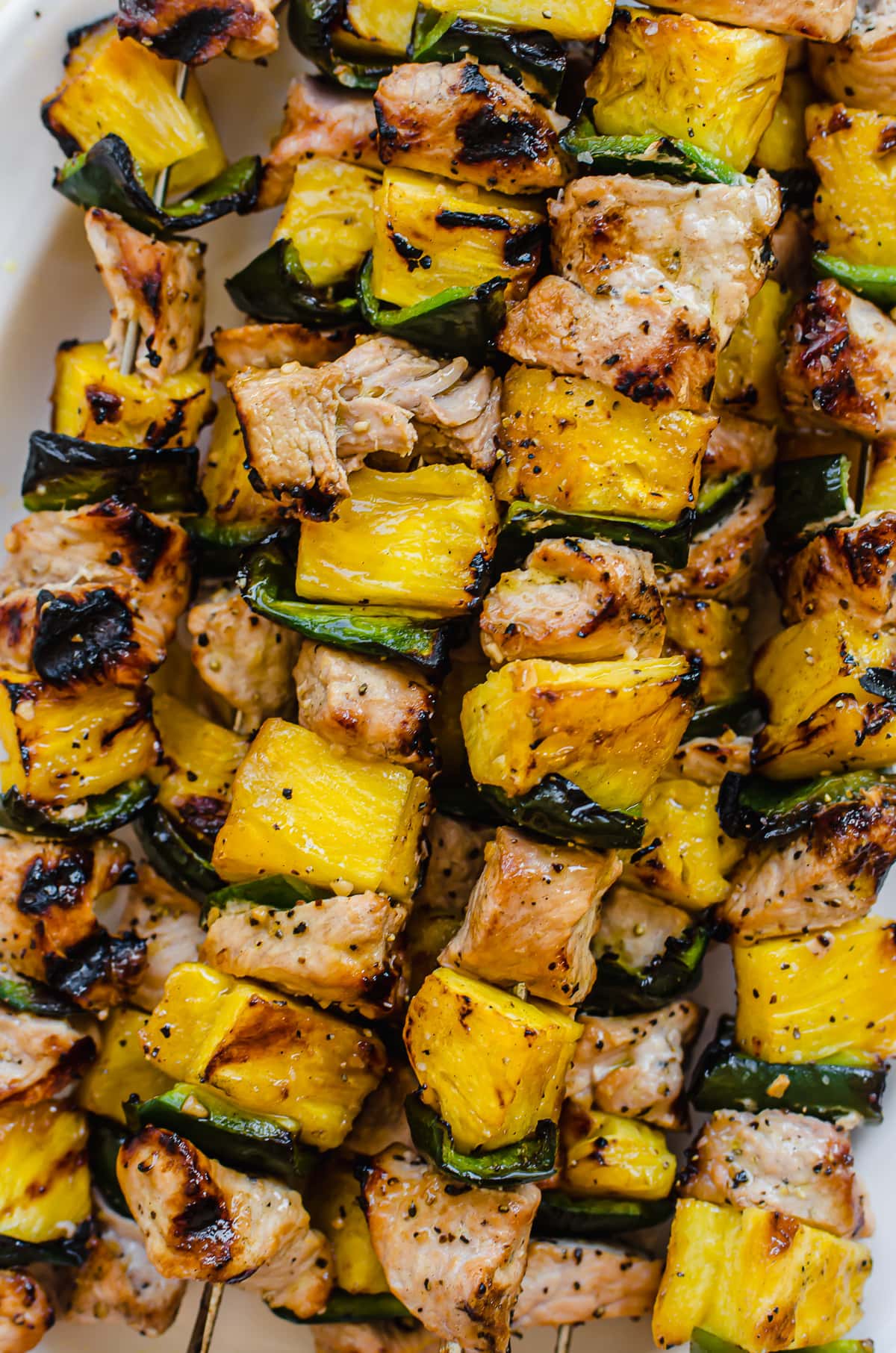 A close up shot of grilled pork kabobs with pineapple.
