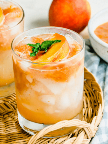 A short glass tumbler filled with peach lemonade.