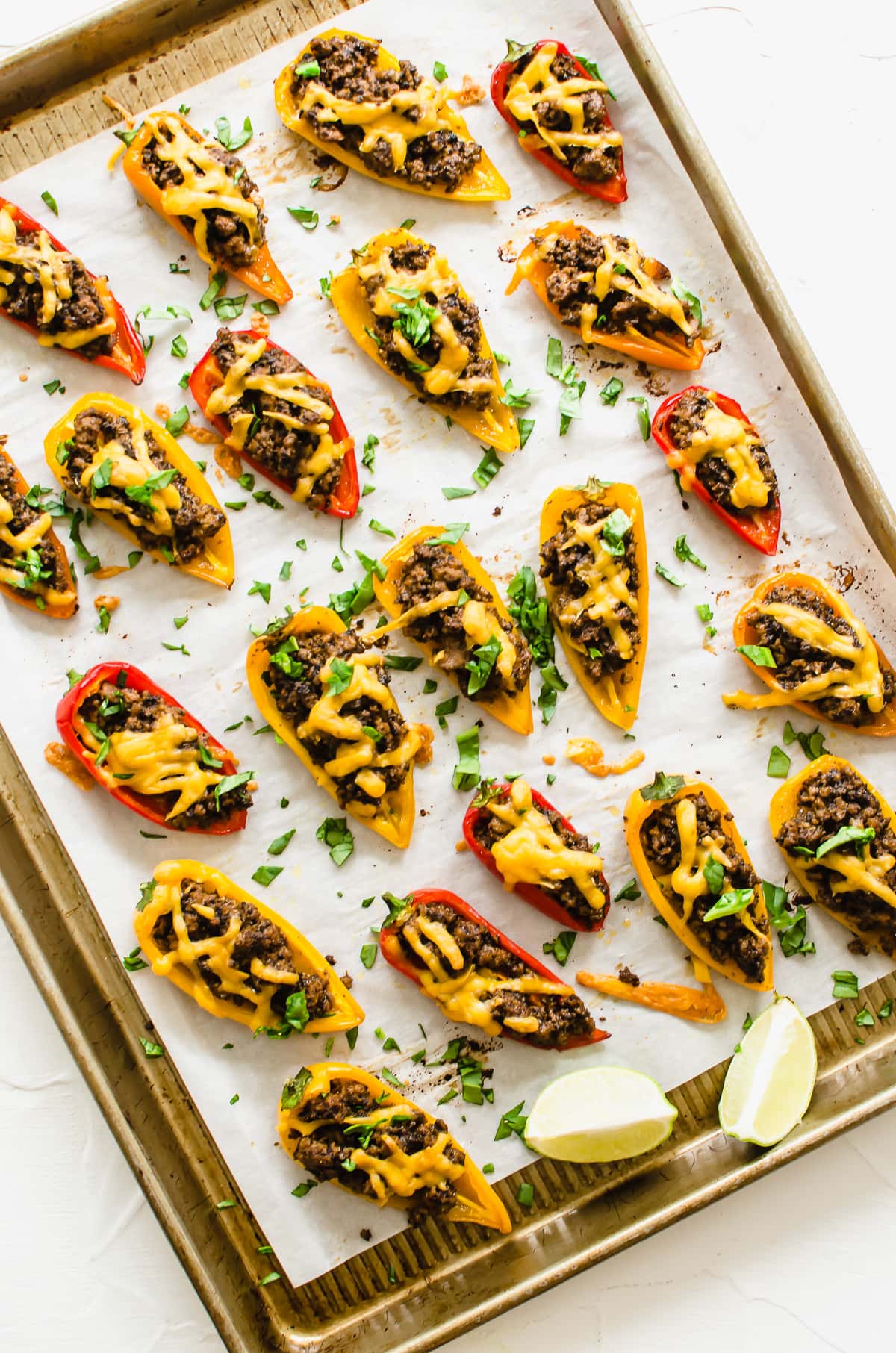 A parchment paper lined baking sheet with bell pepper nachos.