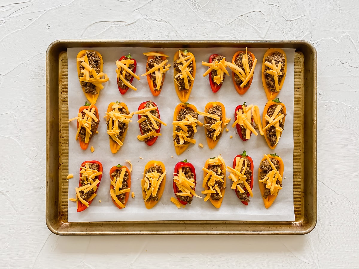 Unbaked bell pepper nachos on a baking sheet with parchment paper.