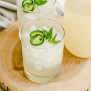 A glass of jalapeño lemonade on a wooden tray.