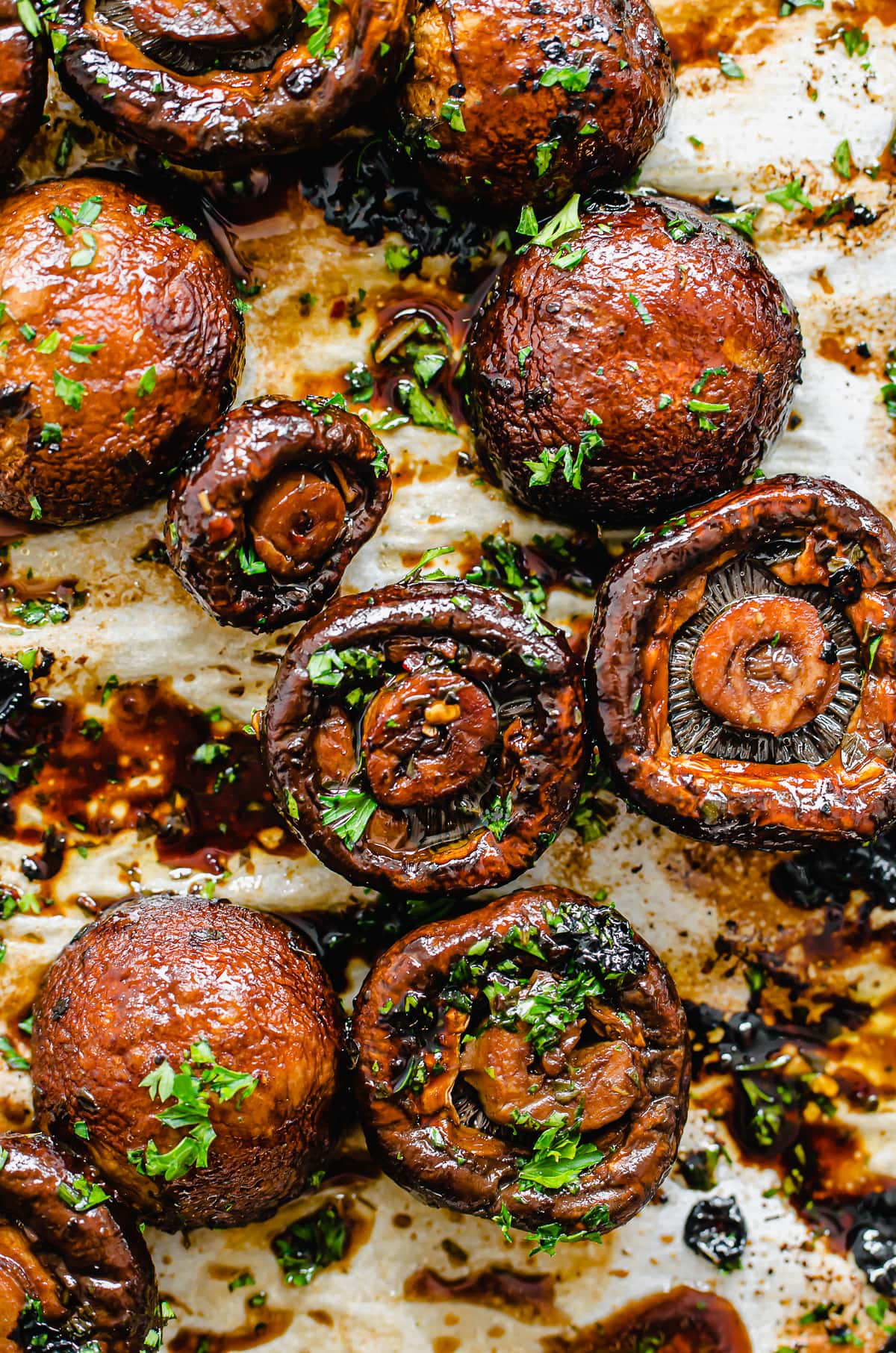 Close-up shot of roasted mushrooms on a baking sheet lined with parchment paper.